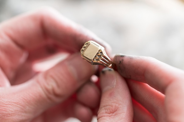 Gros plan des mains de bijoux Maker à l'aide d'une machine à polir