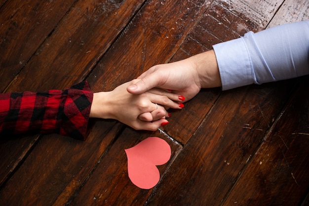 Gros plan des mains avec des coeurs rouges valentines le jour de la Saint-Valentin