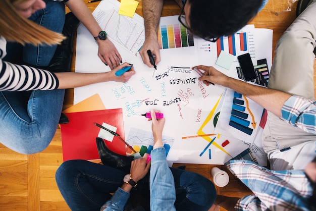 Gros plan des mains des concepteurs travaillant sur de nouvelles idées pour leur travail.