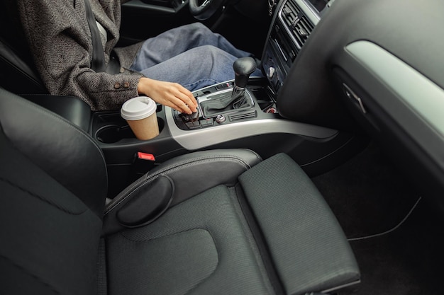 Gros plan sur les mains de la conductrice utilise le système de contrôle de la voiture