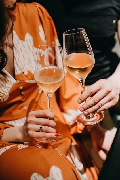 Gros plan des mains d'un couple avec des verres de champagne.