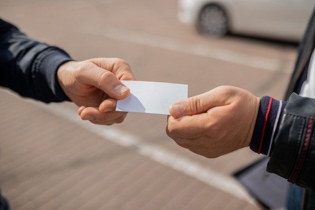 Gros plan des mains de deux personnes échangeant une carte de visite