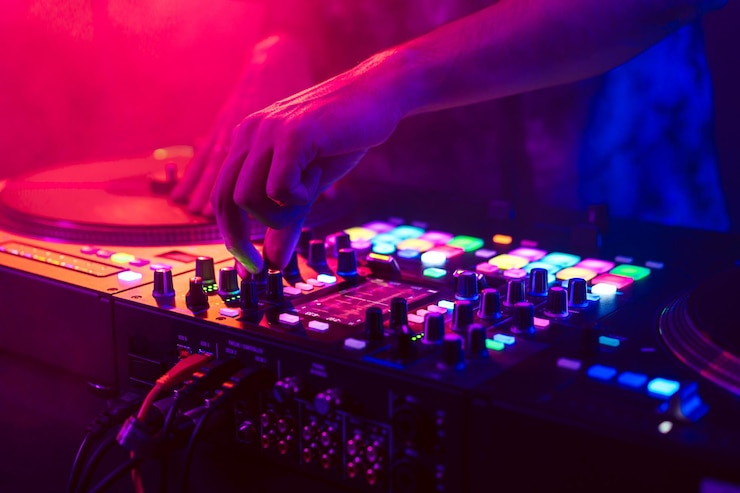 Photo gros plan des mains de dj sur la table de mixage de la console dj pendant le concert dans le club