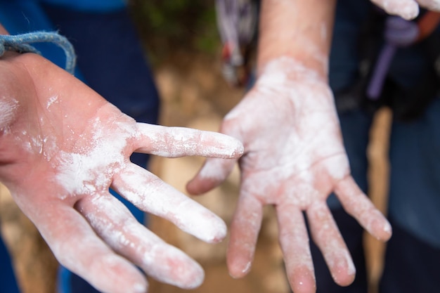 Gros plan des mains du grimpeur avec du magnésium blanc prêt à grimper