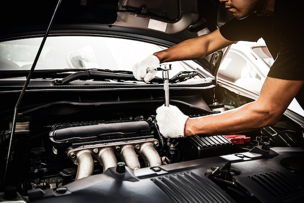 Gros Plan Sur Les Mains Du Mécanicien Automobile Utilisant La Clé Pour Entretenir Le Moteur De La Voiture.