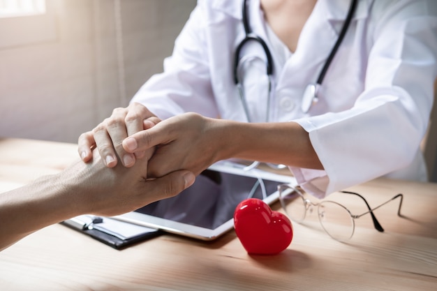 Gros plan des mains du médecin rassurant sa patiente pour des encouragements à l&#39;hôpital