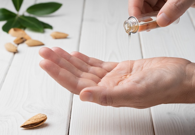 Gros plan des mains féminines lors de l'application d'une lotion hydratante afin de réparer la peau abîmée et sèche