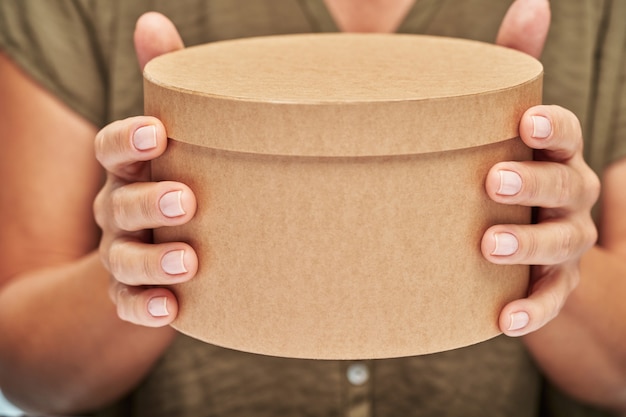 Gros plan de mains féminines tenant une boîte-cadeau