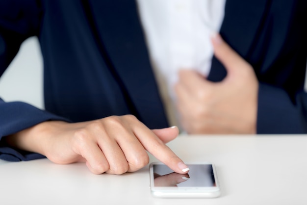 Gros plan des mains de femme d&#39;affaires à l&#39;aide de smartphone sur un écran vide