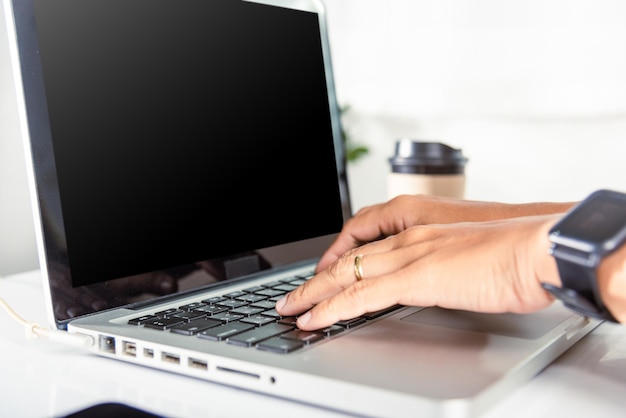 Gros plan sur les mains d'une femme d'affaires sur le clavier d'un ordinateur portable pendant le travail au bureau