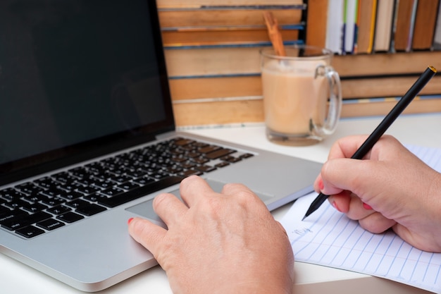 Gros plan des mains de la femme à l'aide d'un ordinateur portable. e-learning