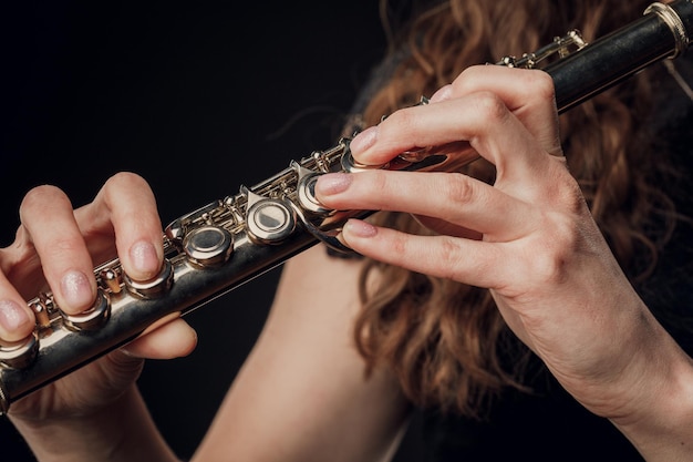 Gros plan des mains d'une femme jouant de la flûte Concept musical