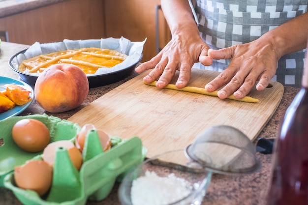 gros plan sur des mains de femme préparant un gâteau avec des ingrédients crus frais naturels comme des pâtes farina pêche et des œufs et de l'eau pour une nourriture saine mais savoureuse pour les parents et les amis à la maison - travailler dans la cuisine