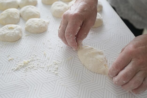 Gros plan des mains de grand-mère Une femme âgée prépare des tartes dans la cuisine