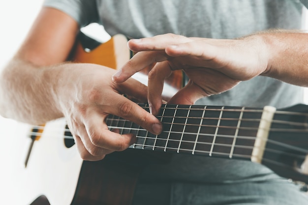 Gros plan sur les mains d'un guitariste jouant de la guitare classique en technique de tapotement à deux mains.