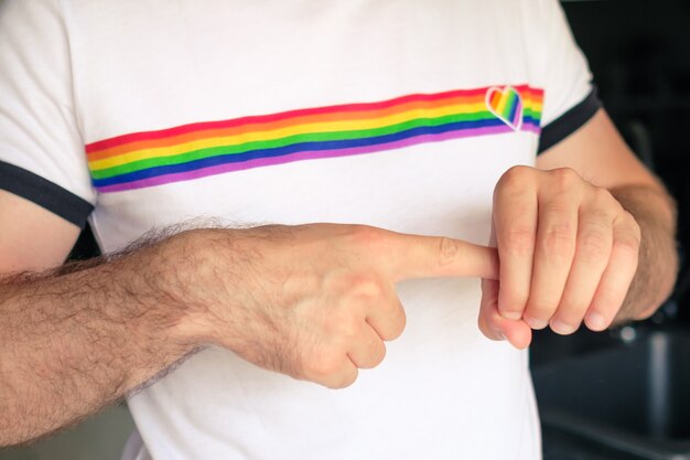 Gros plan sur les mains de l'homme dans le t-shirt avec le concept des droits des homosexuels et des lesbiennes du drapeau lgbt