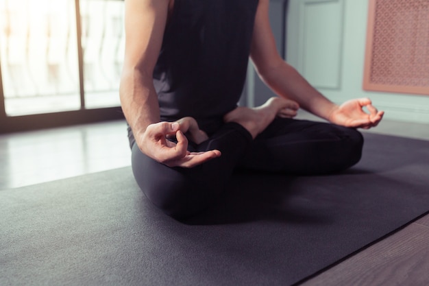 Gros plan sur les mains de l'homme faisant du yoga lotus pose