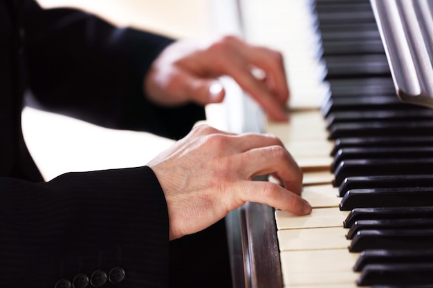 Gros plan des mains de l'homme jouant du piano