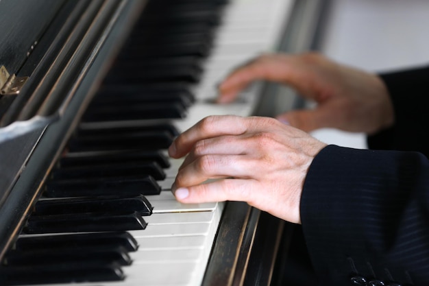 Gros plan des mains de l'homme jouant du piano