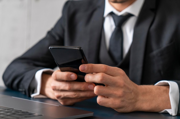 Gros plan des mains de l'homme avec téléphone au bureau