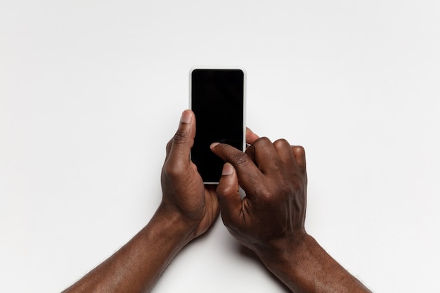 Gros plan des mains humaines à l'aide d'un smartphone avec écran noir vierge