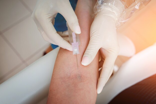 Gros plan des mains de l'infirmière prenant un échantillon de sang