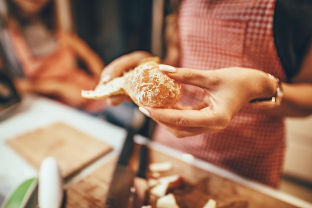 Gros plan sur les mains de la jeune femme épluchant la mandarine dans la cuisine domestique.