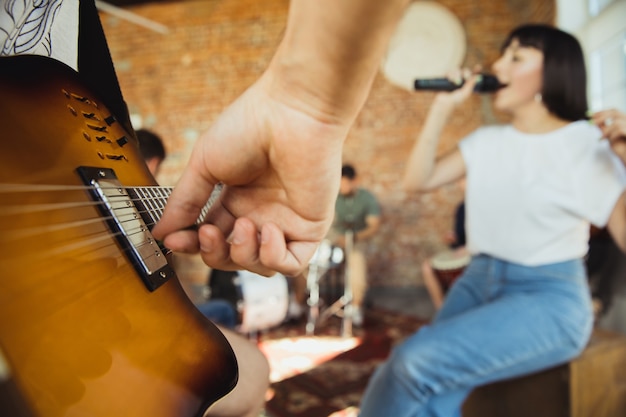 Gros plan sur les mains jouant un groupe de musiciens se brouillant dans un lieu de travail artistique avec des instruments