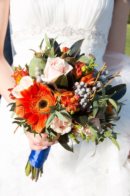 Gros plan des mains de mariée tenant beau bouquet de mariage automne.