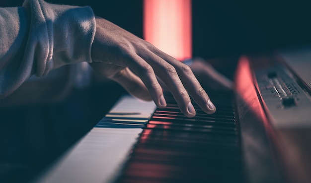 Gros plan des mains masculines jouant les touches du piano