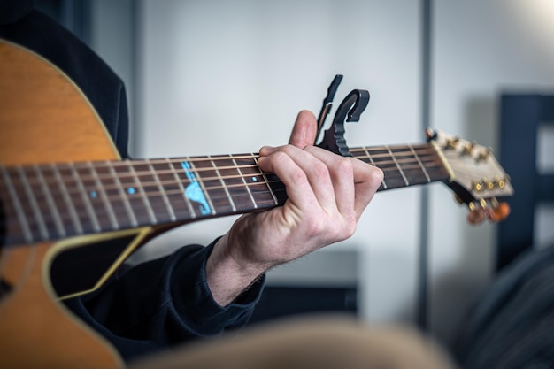 Gros plan des mains masculines jouent de la guitare