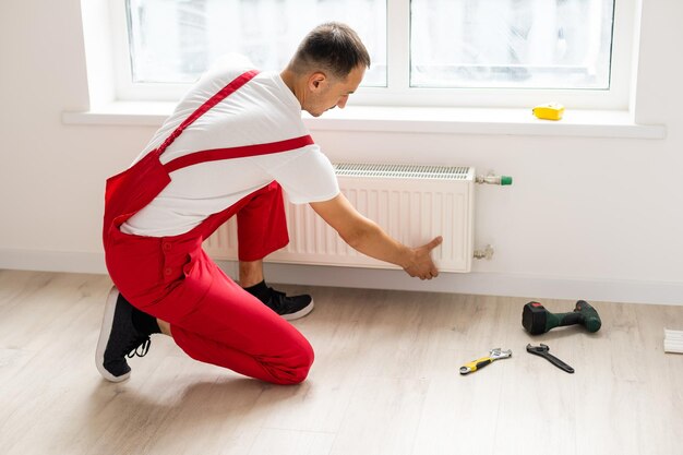 Gros plan sur des mains de mécanicien matures réparant le système de chauffage.