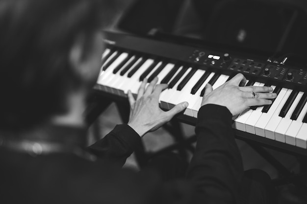 Photo gros plan des mains d'un pianiste en jouant du piano