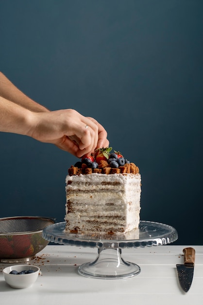 Gros plan sur les mains pour décorer le gâteau