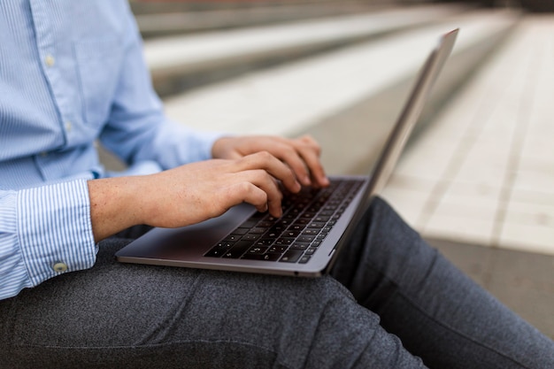 Gros plan des mains tapant sur le clavier de l'ordinateur portable