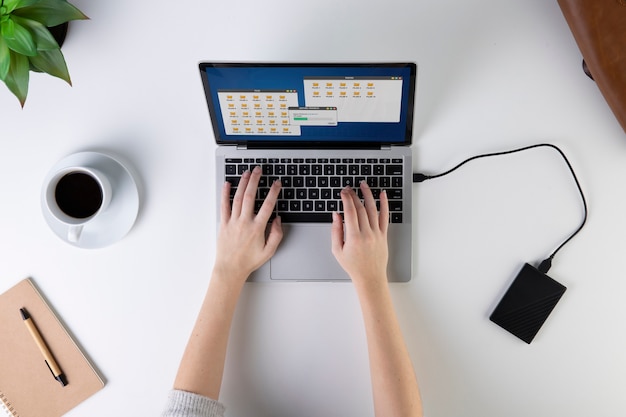 Gros plan des mains tapant sur la vue de dessus de l'ordinateur portable