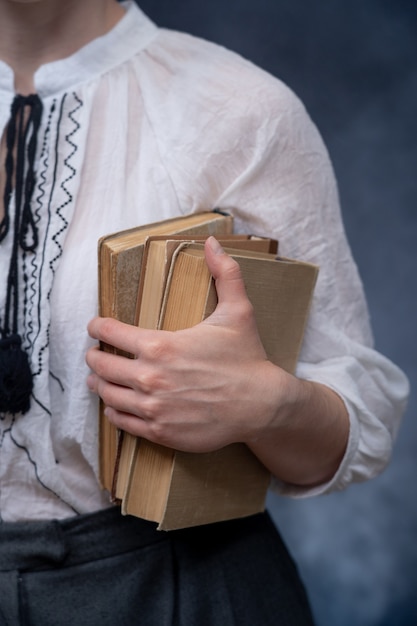 Gros plan des mains tenant une pile de livres