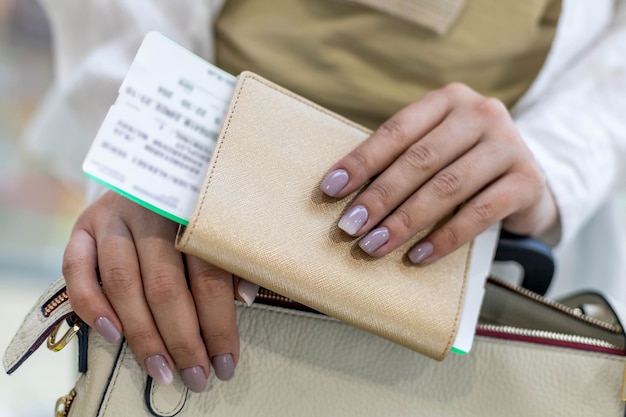 Gros plan des mains touristiques féminines vérifiant les documents passeport et billet préparez-vous à embarquer à l'aéroport