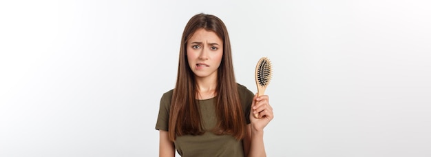 Gros plan malheureux jeune femme frustrée surprise qu'elle perd ses cheveux a remarqué des pointes fourchues cheveux fuyants