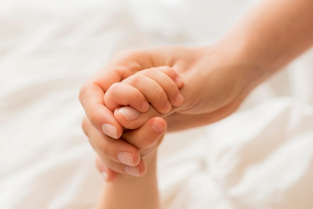 Photo gros plan, maman bébé, tenant mains