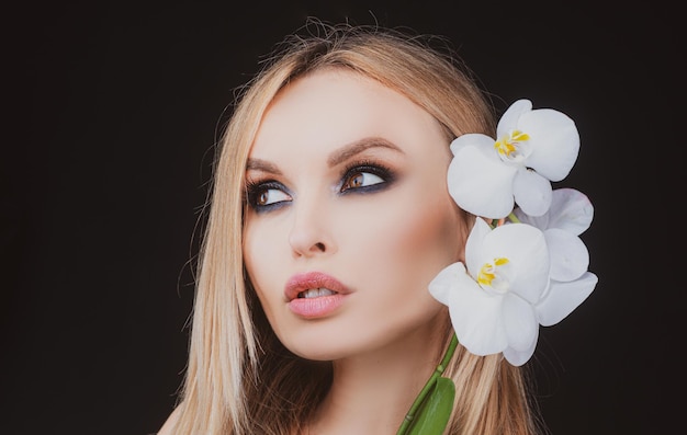 Gros plan de maquillage avec fleur d'orchidée Concept de soins de beauté