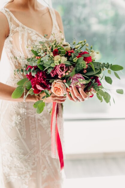 Gros plan de la mariée tenant son bouquet de mariée