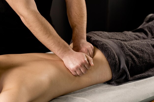 Gros plan sur le massage classique Massage thérapeutique avec manipulation du corps pour favoriser la relaxation et réduire le stress Le massothérapeute utilise des techniques telles que l'étirement par friction et le tapotement