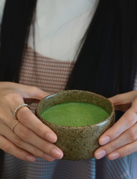 Gros plan matcha chaud dans la main féminine