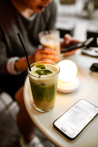 Gros plan sur matcha latte sur la table de café ronde avec homme assis