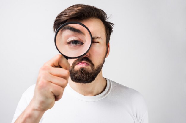 Gros plan d'un mec suspect en chemise blanche regardant droit devant la vitre. Il a l'air étrange et pas content du tout. Vue en coupe. Isolé sur blanc.