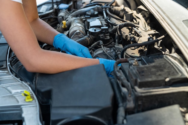 Gros plan d'un mécanicien professionnel travaillant sur un véhicule dans un service de voiture