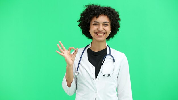 Photo un gros plan de médecin sur un fond vert montre le signe ok