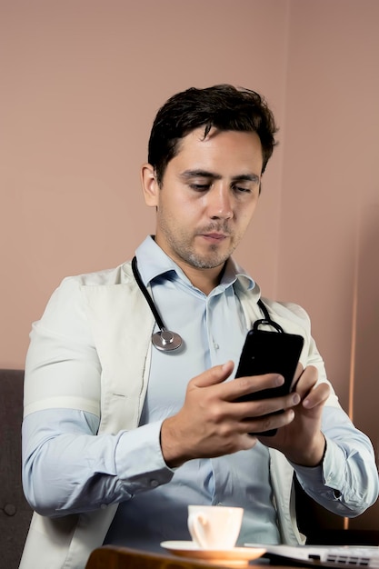 Gros plan sur un médecin utilisant un téléphone dans son bureau médecin travaillant en ligne