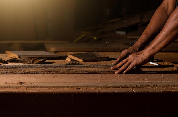 Gros plan d'un menuisier utilisant une scie circulaire ou un outil pour couper des planches de bois Pour fabriquer des meubles dans des maisons et des résidences, des hôtels, des chambres en bois.